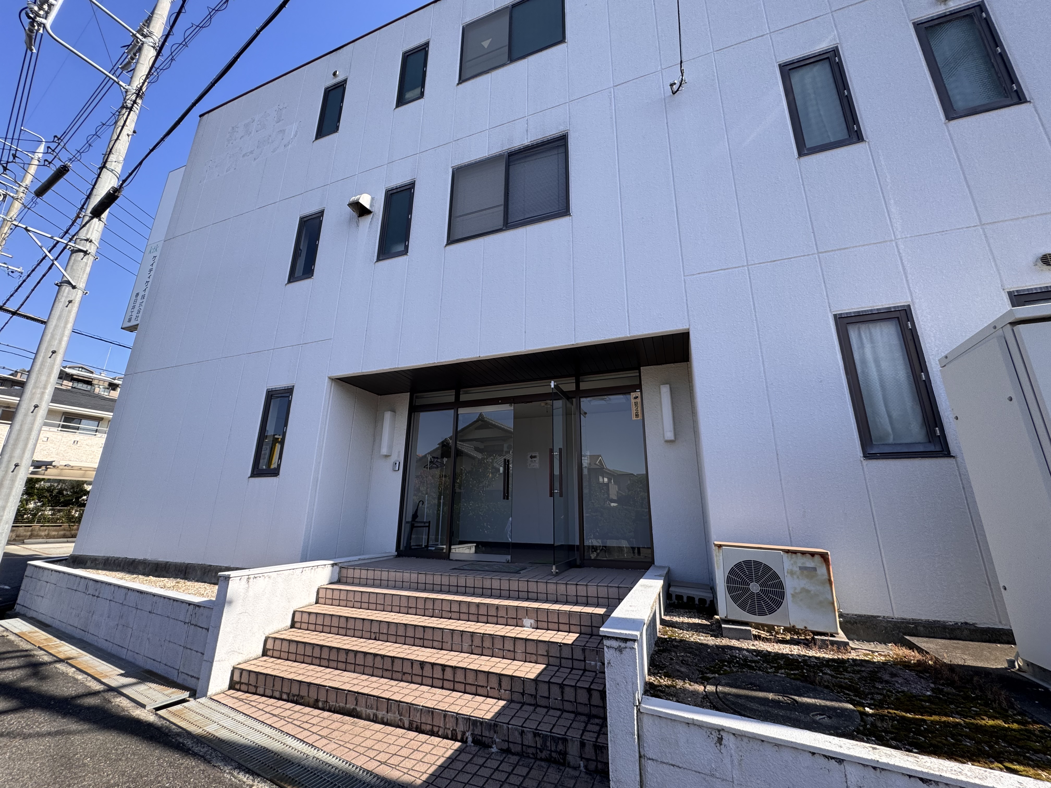 ケイティケイ株式会社 春日井工場の正面外観と建物入口