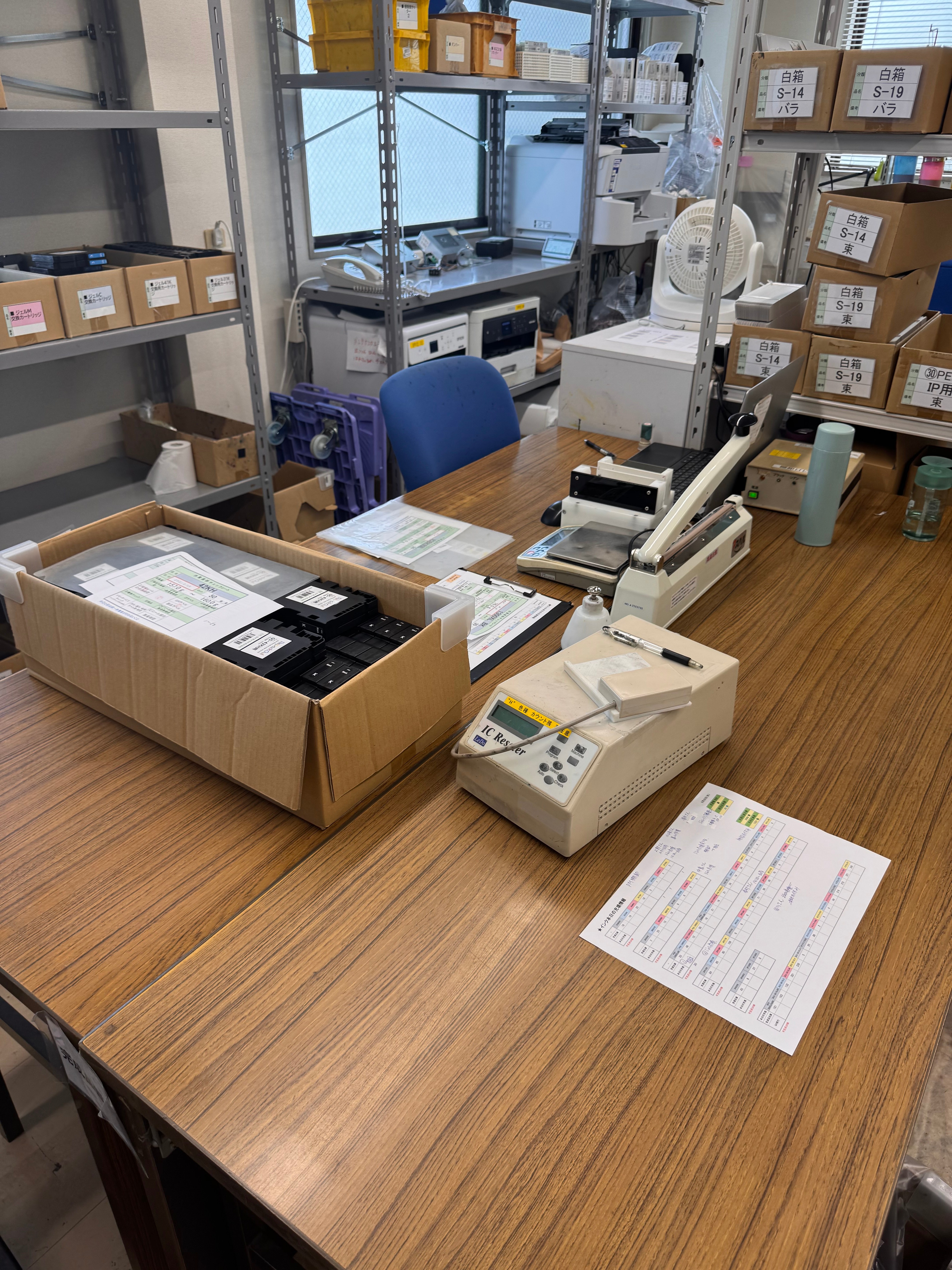 製品や確認用設備、書類が置かれた工場内の作業台